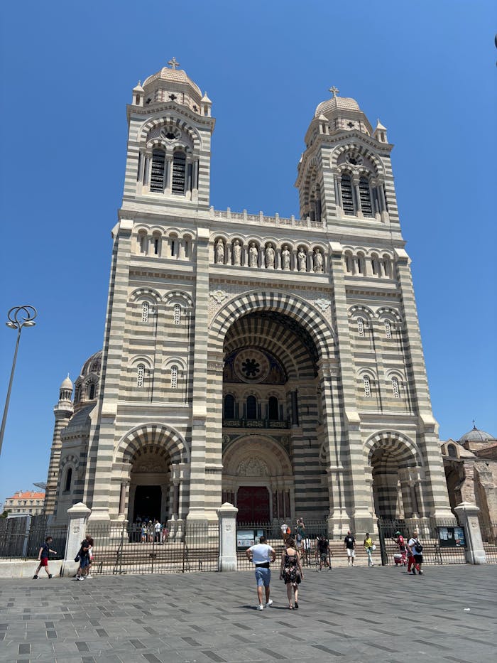gallery-5 Marseille Cathedral's grand architecture under a clear blue sky with visitors.