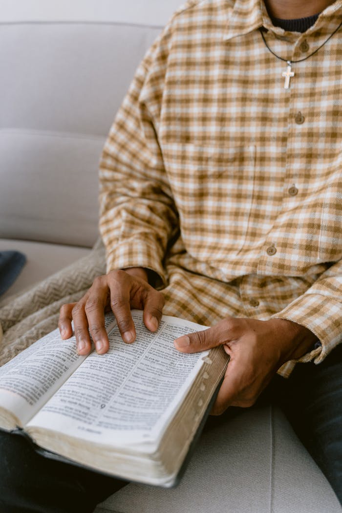 gallery-1 A close-up of a man reading a Bible, emphasizing faith and reflection.